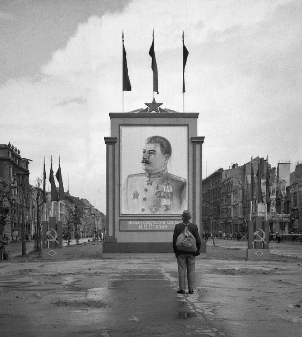 A-German-civilian-looks-at-a-newly-placed-poster-of-Stalin-on-the-Unter-den-Linden-in-Berlin-1945.